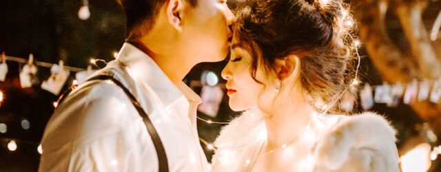 man kissing woman's forehead